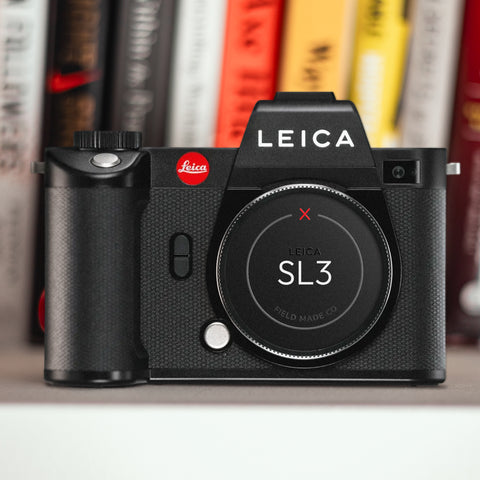Leica SL3 camera with Field Made Co sticker label on a shelf with books in the background